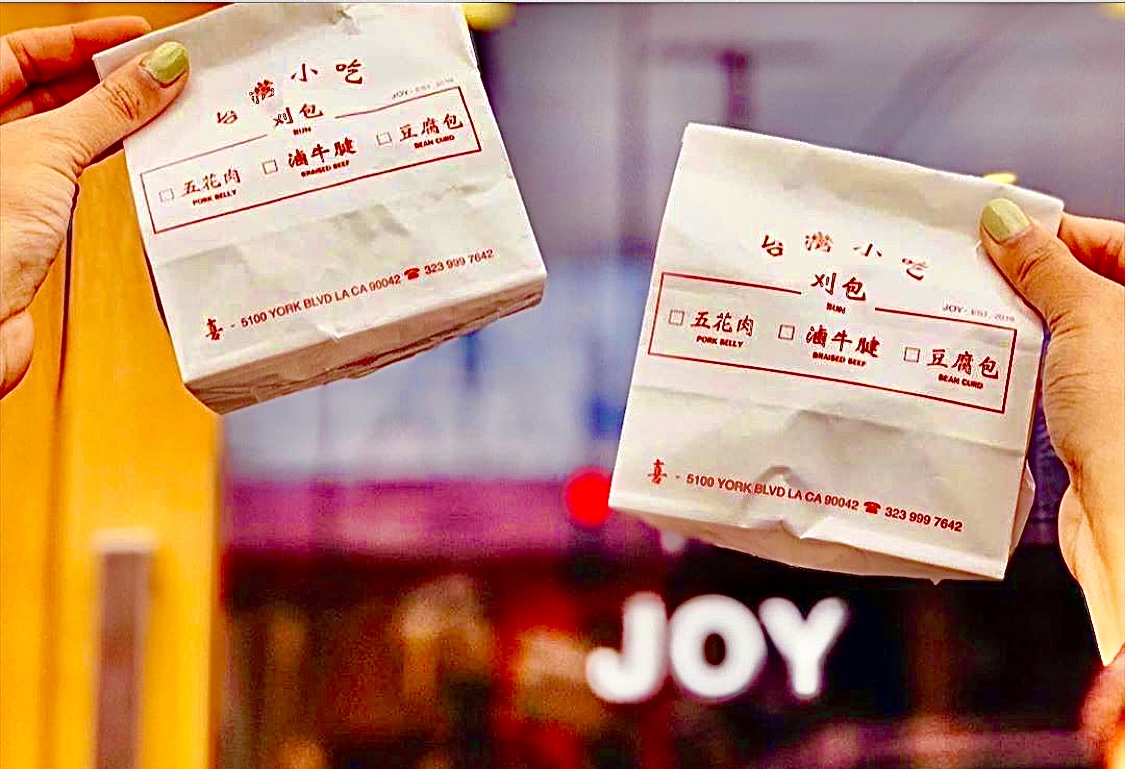 Hands holding Joy Taiwanese gua bao order.
